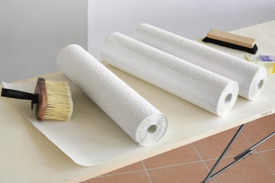 Drei Rollen Tapete und Tapezierwerkzeug